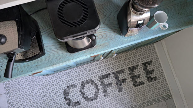 photo of kitchen floor with the word COFFEE tiled into it